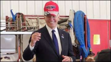 US President Joe Biden wearing a "Trump 2024" hat.