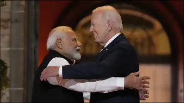 President Joe Biden talks with India's Prime Minister Narendra Modi as he leaves the Quad leaders summit.