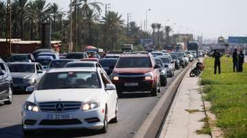 People in heavy traffic drive north from Lebanon's southern coastal city Sidon as some of them flee 