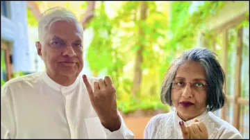 Sri Lankan President Ranil Wickremesinghe along with his wife shows his ink-marked finger after casting their vote for the presidential election.