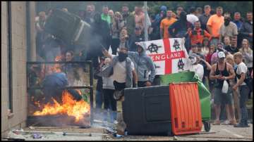 Demonstrators toss a trash bin during an anti-immigration protest in the United Kingdom.