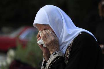 Jamileh Ramadan, cries as she visits the grave of her granddaughter Julia Ramadan, who was killed on Sept. 29 in Ain el Delb during the deadliest Israeli airstrike on a residential building