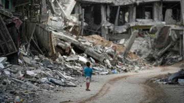 A child walks through the destruction left by the Israeli air and ground offensive on Khan Younis, G