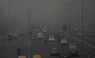 Vehicles ply on a road amid low visibility due to smog in Ghaziabad