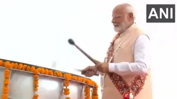 Prime Minister Narendra Modi takes a turn playing a traditional dhol at the Jagdamba Mata Temple in Poharadevi.