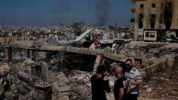 People stand amid damage caused by Israeli airstrikes in Beirut.