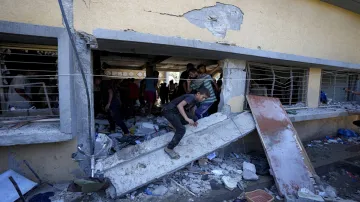 Palestinians search for the bodies of their relatives killed in an Israeli bombardment of a school in central Gaza Strip