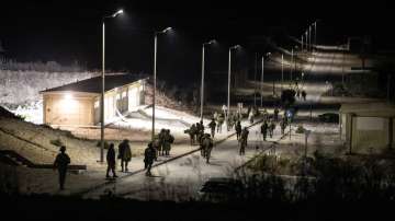 Israeli soldiers walk near the scene where a drone from Lebanon attacked Israel.