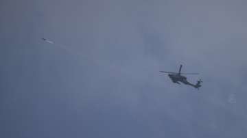 An Israeli Apache helicopter fires a missile towards southern Lebanon as tensions escalate.