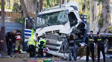 Israeli police and rescue services inspect the site where a truck driver rammed into a bus stop near