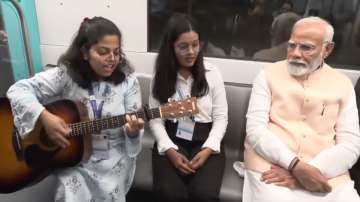 A girl performs music during PM Modi's metro ride 