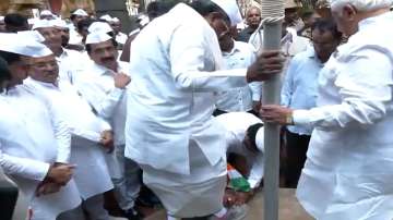 A Congress worker with the Tiranga in his hands removes shoes of Karnataka CM Siddaramaiah.