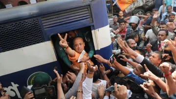 Bangladeshi Hindu leader Krishna Das Prabhu shows a victory sign as he is taken in a police van after court ordered him detained pending further proceedings in Chattogram in southeastern Bangladesh