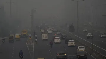 Vehicles ply on a road amid low visibility due to smog in Delhi