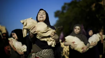 Pro-Palestinian activists perform during a march marking the International Day for the Elimination o