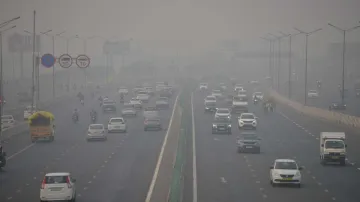 Vehicles ply on the road amid low visibility due to smog