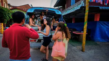 Tourists talk to a bar owner in Vang Vieng, Laos