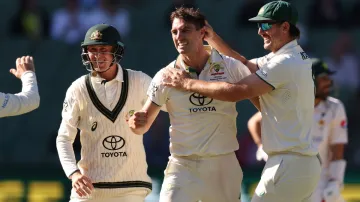 Pat Cummins celebrates a wicket with Mitchell Marsh and Marnus Labuschagne.