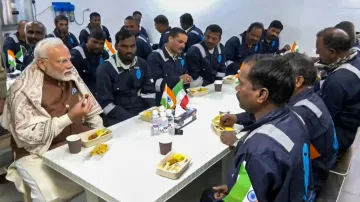 PM Modi sharing a light moment with Indian workers in Kuwait.