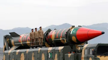 Pakistani military personnel stand beside a Shaheen III surface-to-surface ballistic missile during 