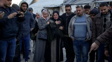 Palestinians react next to the bodies of their relatives who were killed in the Israeli bombardment 