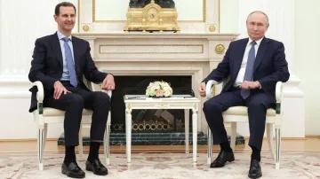 Russian President Vladimir Putin attends a meeting with then-Syrian President Bashar al-Assad at the