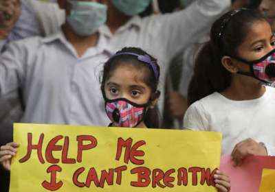 An Indian girls holds a banner during a protest against air pollution in New Delhi, India, Sunday, Nov. 6, 2016. The Delhi government has ordered that all city schools be shut, construction activity halted and all roads be doused with water as crippling air pollution has engulfed the Indian capital. The city, one of the world's dirtiest, has seen the levels of PM2.5 soar to over 900 microgram per cubic meter on Saturday, more than 90 times the level considered safe by the World Health Organization and 15 times the Indian government's norms.