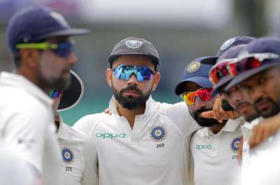 Virat Kohli stands in a huddle with his teammates before the start of fourth day's play in Colombo