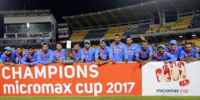 Members of Indian cricket team pose for photographers with the winners' trophy after winning their only T20I against Sri Lanka in Colombo