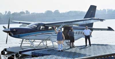 Prime Minister Narendra Modi waves to the crowd as he boards a seaplane on the Sabarmati river front in Ahmedabad on Tuesday