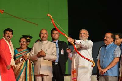 Prime Minister Narendra Modi releases the arrow with a bow to symbolically set on fire the effigy of evil king Ravana during Dussehra celebrations of Luv Kush Ramleela Committee at Red Fort ground in New Delhi. President Ram Nath Kovind, Union minister Harsh Vardhan and Delhi BJP President Manoj Sinha are also seen.