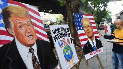 Art teacher Sagar Kambli makes paintings of President Donald Trump and his Democrat rival Joe Biden on a pavement outside his art school, remaining closed due to the COVID-19 pandemic, in Mumbai.