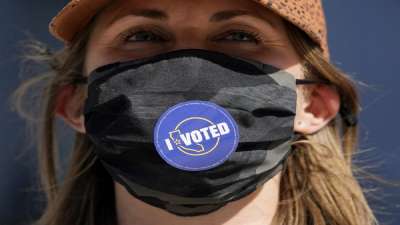 Lillian Lauer wears an I Voted sticker on her face mask after dropping off her ballot at a San Francisco Department of Elections drop-off location at the Chase Center in San Francisco.