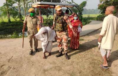 ITBP personnel, deployed on election duty, at polling booths in Rishra of Hooghly district help an elderly woman as she arrives to cast her vote for the fourth phase of West Bengal Polls.