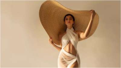 Shanaya Kapoor flaunts her curves in a white bikini and a sarong that drapes around her body. She completes this sultry look with an over-sized straw hat