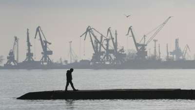 A man walks in front of harbor cranes at the port in Mariupol, Ukraine, Wednesday, Feb 23, 2022. Mariupol, which is part of the industrial region in eastern Ukraine known as the Donbas, has been a key objective for Russia since the start of the Feb 24 invasion.&amp;nbsp;