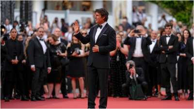 Tom Cruise is surrounded by photographers as he poses on the Cannes red carpet ahead of his film Top Gun: Maverick premiere
