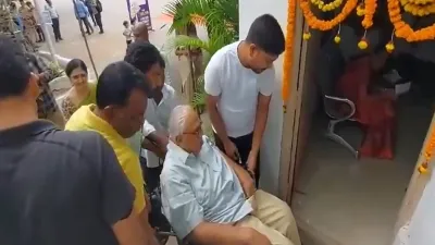 A senior citizen voter in a wheelchair assisted by polling volunteers at a polling booth in JubileeHills in Hyderabad.