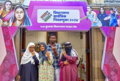 People show their inked fingers after casting their votes during the Maharashtra Assembly elections in Mumbai