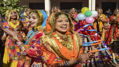 School students and teachers dressed in traditional Punjabi attire perform Punjabi folk dance Giddha during Lohri festival celebration at a school. 