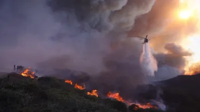 Water is dropped by a helicopter on the advancing Palisades fire in the Pacific Palisades neighbourhood of Los Angeles on Tuesday. A third wildfire started around 10.30 pm and quickly prompted evacuations in Sylmar, a San Fernando Valley community that is the northernmost neighbourhood in Los Angeles. 
