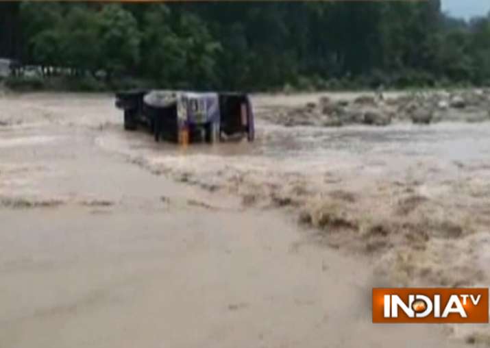 A woman died as a bus tumbled into a local stream in