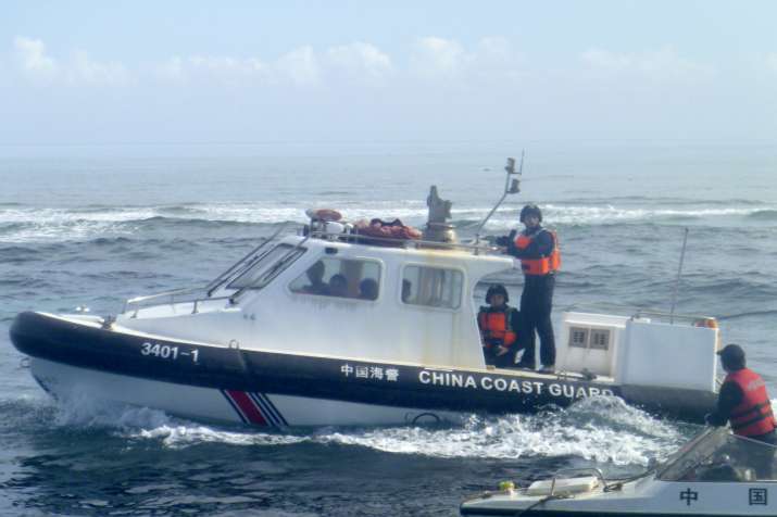 A Chinese Coast Guard boat approaches Filipino fishermen in