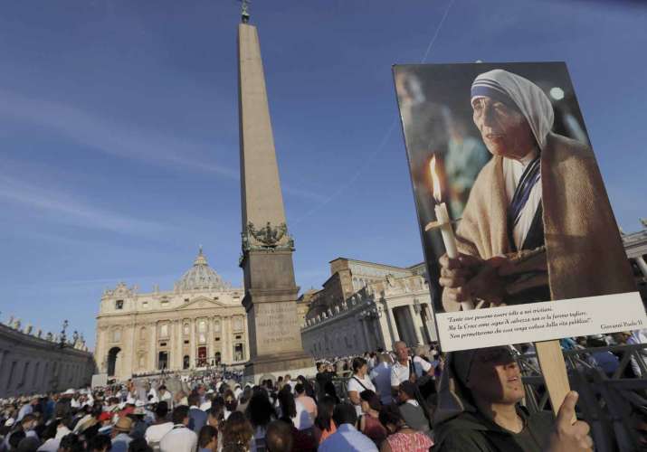 A nun holds a photo of Mother Teresa before the start of