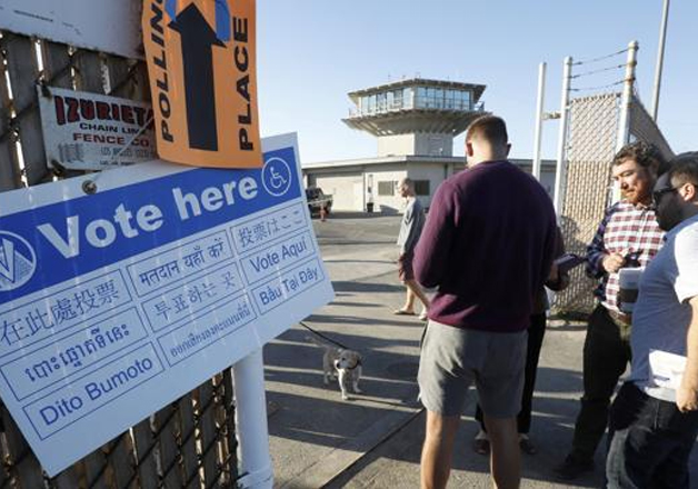 People wait in line to vote at a polling station in Los
