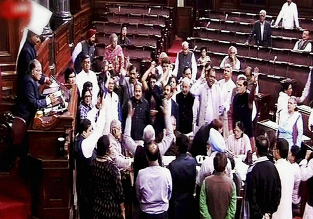 Opposition members protest in the well of the Rajya Sabha