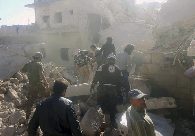 Civil Defense workers inspect damaged buildings after