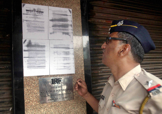 A police constable reads the ban order pasted outside IRF