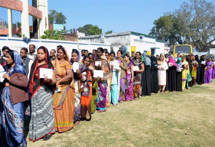 Women voters wait to cast their votes at a polling station