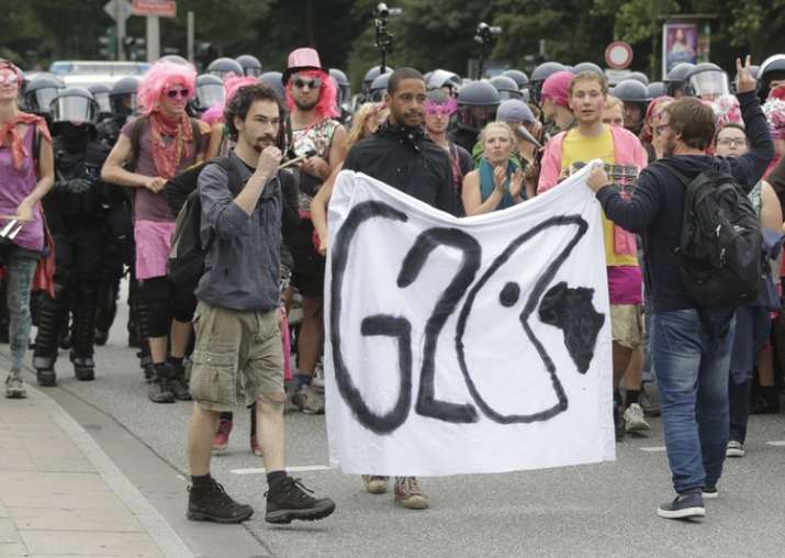 Protestors hold posters on the first day of G20 summit in